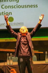 John Perkins beginning his talk with some group energising breathing exercises. Picture taken by Boris Austen