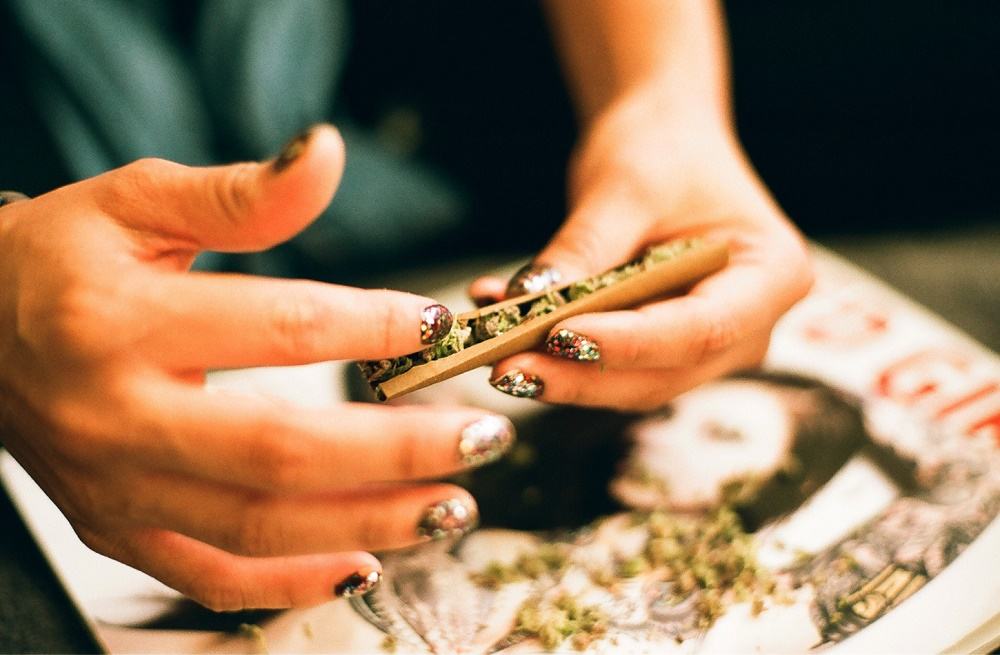 girl rolling joint