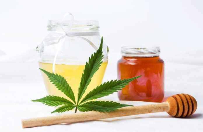 Marijuana leaf and sweet honey in a jar